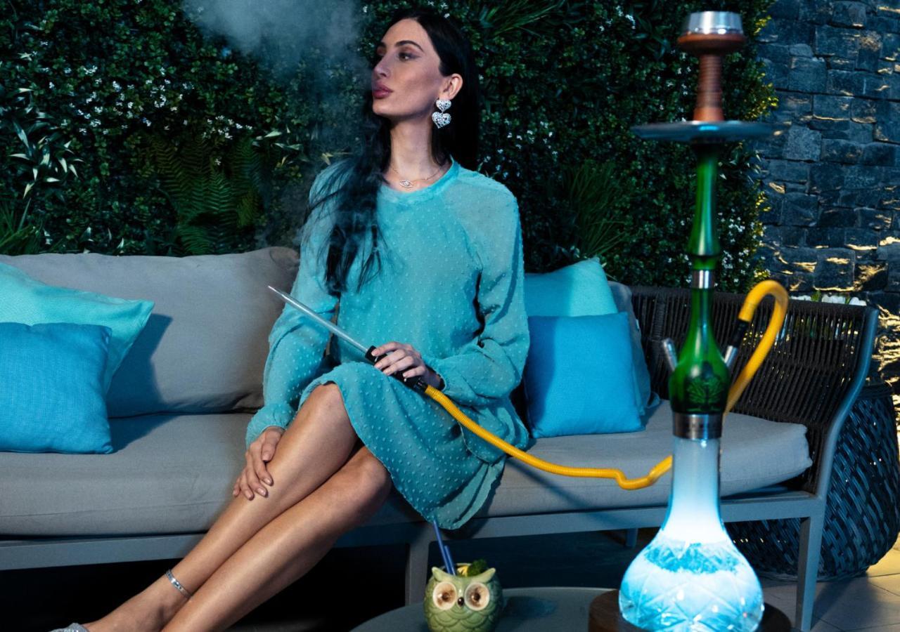 Moevenpick Hotel & Apartments Bur Dubai Esterno foto A woman smoking a hookah